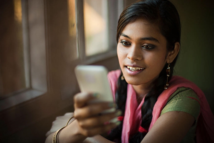 Indian woman reading information on smart phone